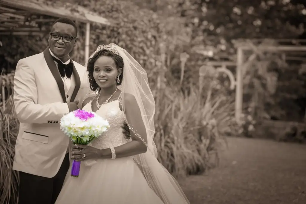 Sepia portrait of a bride and groom with a colour bouquet