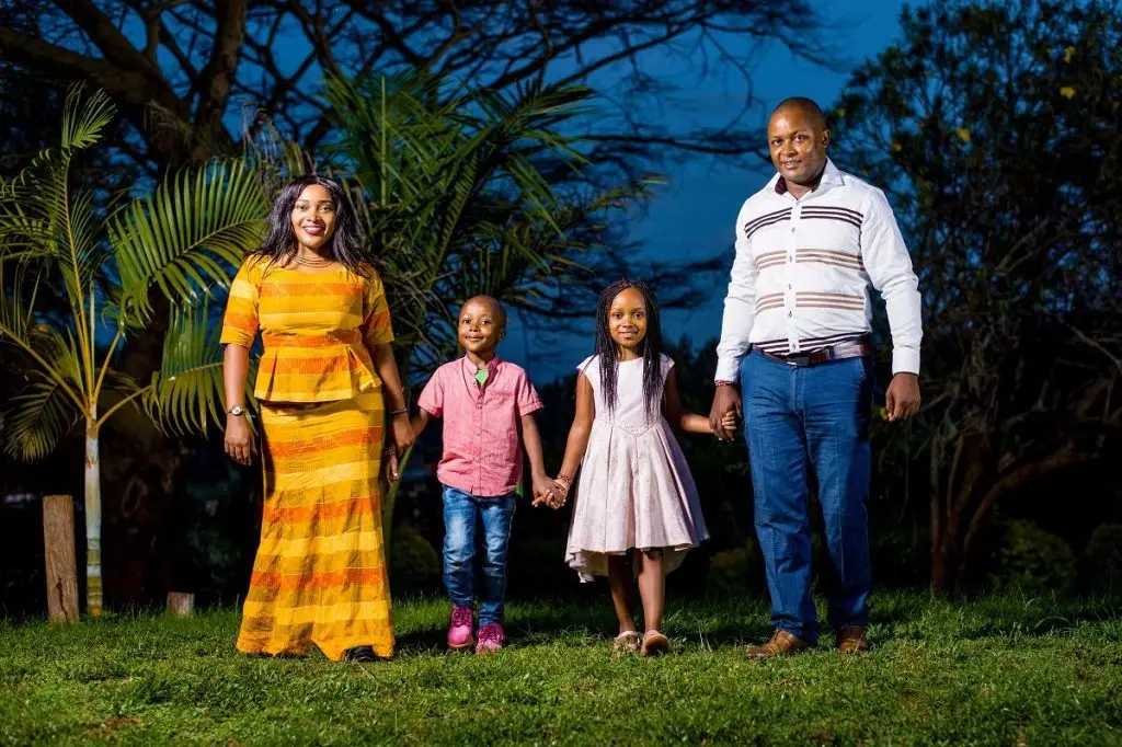 Family of four holding hands at dusk