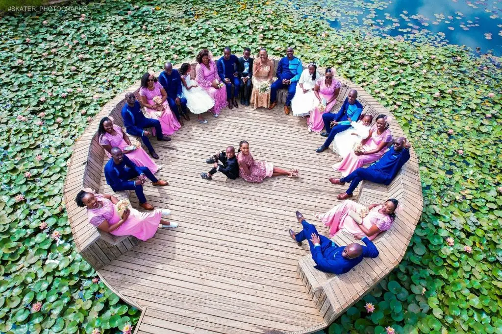 Aerial photo of a wedding party seated on a round deck among water lilies