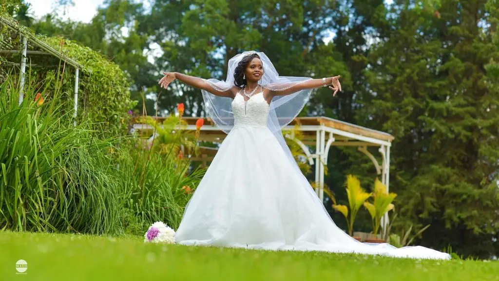 Bride with arms outstretched in a garden